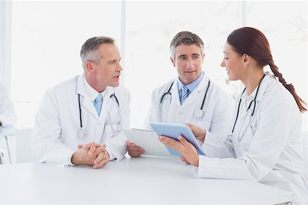 Doctors using a tablet together while sitting Stock Photo - Budget Royalty-Free & Subscription, Code: 400-07752044