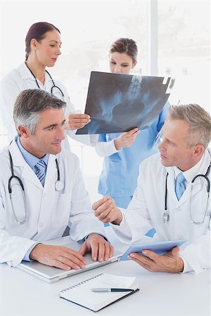 simsearch:400-06799497,k - Doctor holding up an x-ray with fellow doctors Stockbilder - Microstock & Abonnement, Bildnummer: 400-07752059