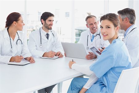 simsearch:640-03257612,k - Doctors sitting together and talking while nurse looks at the camera Stock Photo - Budget Royalty-Free & Subscription, Code: 400-07752052