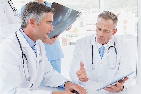 simsearch:640-03257612,k - Doctor holding up an x-ray with fellow doctors Stock Photo - Budget Royalty-Free & Subscription, Code: 400-07752060