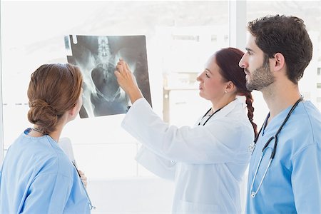 doctors working on teenager - Doctor holding up an x-ray with fellow doctors Stock Photo - Budget Royalty-Free & Subscription, Code: 400-07752063