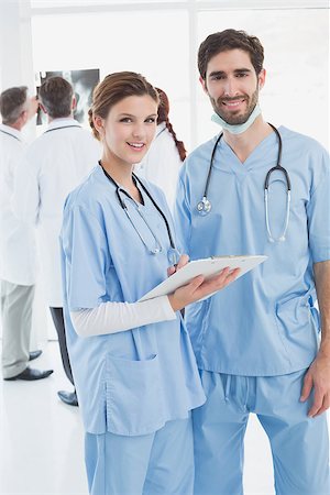 simsearch:400-06799497,k - Nurses holding a file together and smiling at the camera Stockbilder - Microstock & Abonnement, Bildnummer: 400-07752074