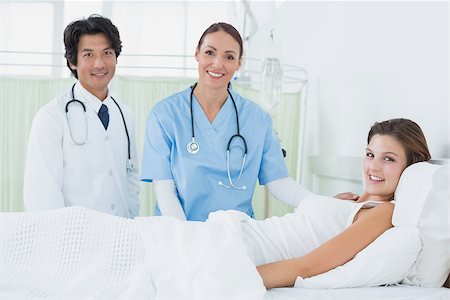 simsearch:685-02938526,k - Nurse and doctor checking patient while looking at camera Stock Photo - Budget Royalty-Free & Subscription, Code: 400-07752111