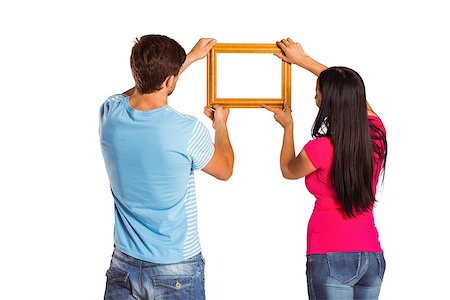 Young couple hanging a frame on white background Stock Photo - Budget Royalty-Free & Subscription, Code: 400-07753340