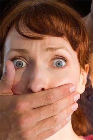 Terrified woman with covered mouth on black background Foto de stock - Super Valor sin royalties y Suscripción, Código: 400-07753553