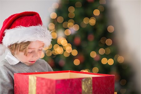 simsearch:400-07753751,k - Child opening his christmas present with tree behind him Stock Photo - Budget Royalty-Free & Subscription, Code: 400-07753756