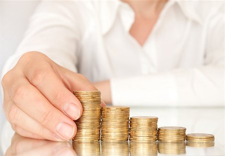 piles of cash pounds - Hand put coins to stack of coins on white background Photographie de stock - Aubaine LD & Abonnement, Code: 400-07774262