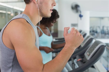 simsearch:400-07777565,k - Fit man and woman running on treadmill at the gym Stockbilder - Microstock & Abonnement, Bildnummer: 400-07777588