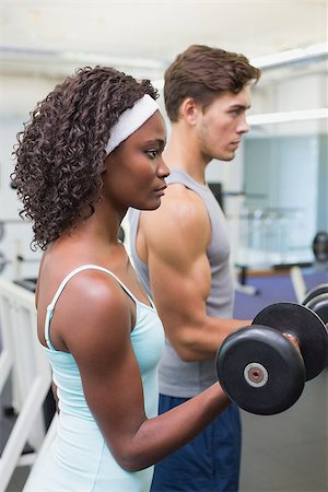 simsearch:400-07777565,k - Fit couple lifting dumbbells together at the gym Stockbilder - Microstock & Abonnement, Bildnummer: 400-07777606