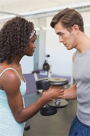 simsearch:400-07777565,k - Fit couple lifting dumbbells together at the gym Stockbilder - Microstock & Abonnement, Bildnummer: 400-07777609