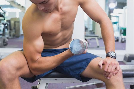 simsearch:400-07333355,k - Fit man lifting dumbbells sitting on the bench at the gym Stock Photo - Budget Royalty-Free & Subscription, Code: 400-07777658