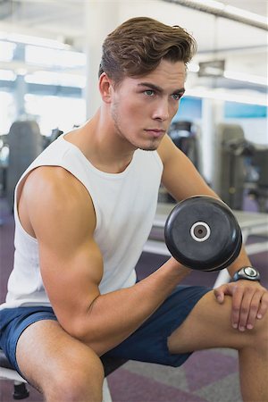 simsearch:400-07333355,k - Fit man lifting dumbbells sitting on the bench at the gym Stock Photo - Budget Royalty-Free & Subscription, Code: 400-07777664