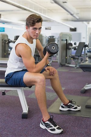 simsearch:400-07333355,k - Fit man lifting dumbbells sitting on the bench at the gym Stock Photo - Budget Royalty-Free & Subscription, Code: 400-07777662