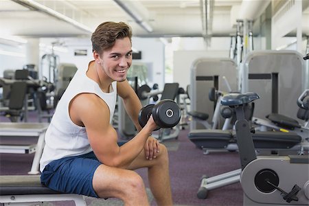 simsearch:400-07333355,k - Fit man lifting dumbbells sitting on the bench at the gym Stock Photo - Budget Royalty-Free & Subscription, Code: 400-07777663