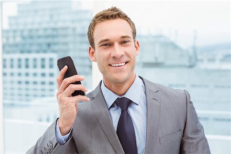 simsearch:400-07139155,k - Portrait of smart young businessman using mobile phone in office Stock Photo - Budget Royalty-Free & Subscription, Code: 400-07777754