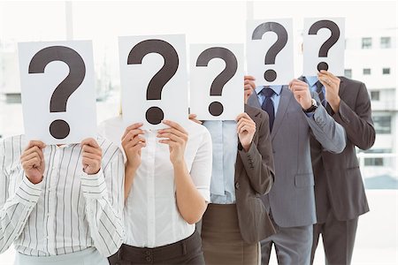 employee hold a sign - Business people holding question mark signs in front of their faces in office Stock Photo - Budget Royalty-Free & Subscription, Code: 400-07777882