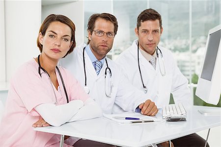 simsearch:400-07778150,k - Portrait of confident doctors at desk in the medical office Stock Photo - Budget Royalty-Free & Subscription, Code: 400-07778486