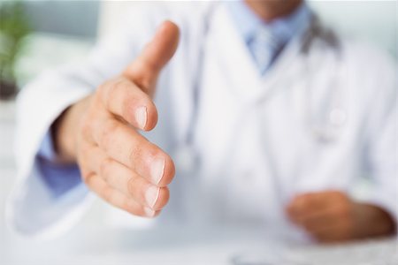 Mid section of blurred male doctor offering handshake at medical office desk Stock Photo - Budget Royalty-Free & Subscription, Code: 400-07778503