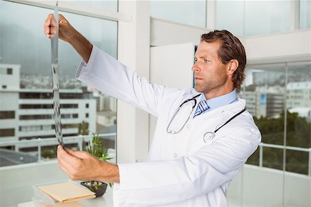 simsearch:400-07274751,k - Serious male doctor examining x-ray in the medical office Foto de stock - Super Valor sin royalties y Suscripción, Código: 400-07778520