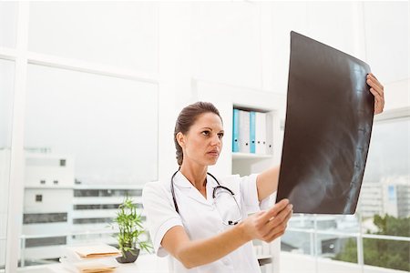 simsearch:400-07274751,k - Serious female doctor examining x-ray in the medical office Foto de stock - Super Valor sin royalties y Suscripción, Código: 400-07778538