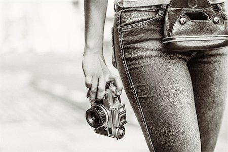 Old fashioned picture of a girl holding a retro camera in the city Photographie de stock - Aubaine LD & Abonnement, Code: 400-07778608