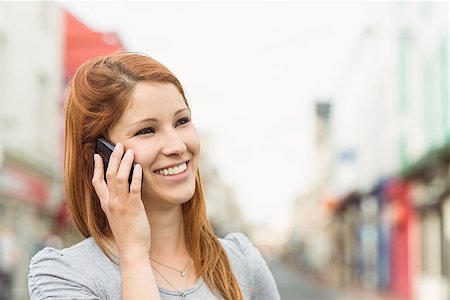 simsearch:400-07778671,k - Smiling woman calling someone with her mobile phone in the city Fotografie stock - Microstock e Abbonamento, Codice: 400-07778634