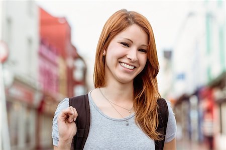 simsearch:400-07778671,k - Portrait of a smiling woman with backpack in the city Fotografie stock - Microstock e Abbonamento, Codice: 400-07778633