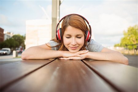 simsearch:400-07778671,k - Woman lying on bench listening to music with eyes closed in the city Fotografie stock - Microstock e Abbonamento, Codice: 400-07778665