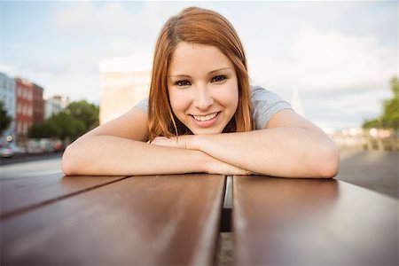 simsearch:400-07778671,k - Portrait of a smiling redhead lying on bench in the city Fotografie stock - Microstock e Abbonamento, Codice: 400-07778663