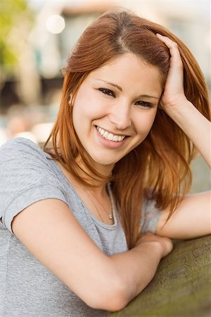 simsearch:400-07778671,k - Pretty redhead smiling at camera in the city Fotografie stock - Microstock e Abbonamento, Codice: 400-07778670