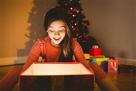 simsearch:400-07753751,k - Little girl opening a glowing christmas gift at home in the living room Stock Photo - Budget Royalty-Free & Subscription, Code: 400-07779147