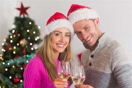 santa christmas hat women - Happy couple enjoying some wine and wearing santa hats Stock Photo - Budget Royalty-Free & Subscription, Code: 400-07779211