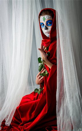 Day of the dead girl with sugar skull makeup holding red rose Stock Photo - Budget Royalty-Free & Subscription, Code: 400-07770954