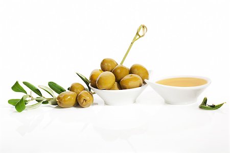 simsearch:400-07617448,k - Delicious green olives and extra virgin olive oil in white round bowls with olive tree twig and leaves isolated on white background. Culinary eating. Foto de stock - Super Valor sin royalties y Suscripción, Código: 400-07771408