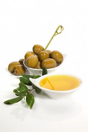 simsearch:400-07617448,k - Green olives and extra virgin oliver oil with olive twig isolated on white background. Traditional olive background. Foto de stock - Super Valor sin royalties y Suscripción, Código: 400-07771409