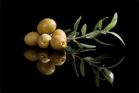 eating olive - Green olives with olive branch isolated on black background. Culinary traditional appetizer. Stock Photo - Budget Royalty-Free & Subscription, Code: 400-07771403