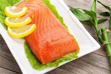 simsearch:400-08187570,k - Fresh salmon fish with lemon and salad leaves on wooden table Stockbilder - Microstock & Abonnement, Bildnummer: 400-07773178