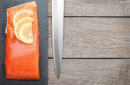 simsearch:400-08187570,k - Fresh salmon fish with lemon and japan knife on wooden table with copy space Stockbilder - Microstock & Abonnement, Bildnummer: 400-07773179