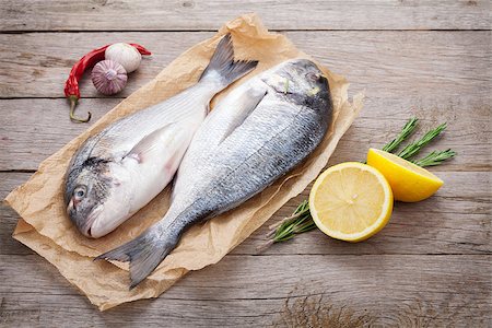 Fresh dorado fish cooking with spices and condiments on wooden table Foto de stock - Super Valor sin royalties y Suscripción, Código: 400-07773206