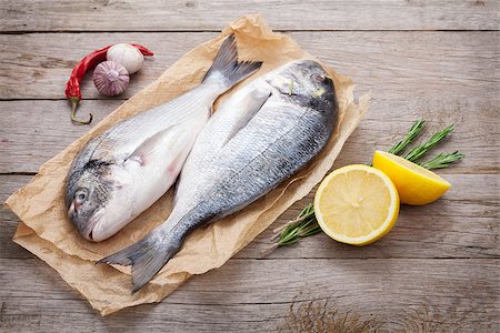 Fresh dorado fish cooking with spices and condiments on wooden table Stockbilder - Microstock & Abonnement, Bildnummer: 400-07773206