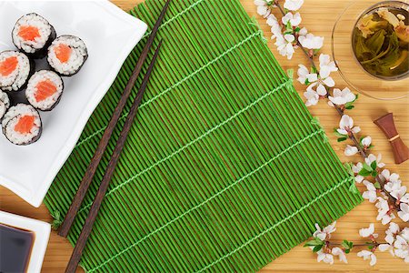 simsearch:400-08072780,k - Sushi maki set, green tea and sakura branch over bamboo table with copy space Stockbilder - Microstock & Abonnement, Bildnummer: 400-07773303