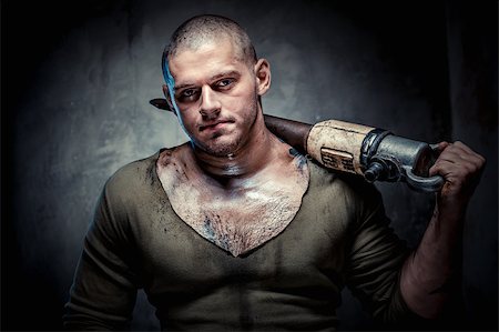 Muscular young man with jackhammer posing over grey background Stock Photo - Budget Royalty-Free & Subscription, Code: 400-07773375