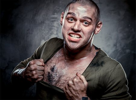 simsearch:400-08333281,k - Aggressive muscular young man posing over grey background Stock Photo - Budget Royalty-Free & Subscription, Code: 400-07773378
