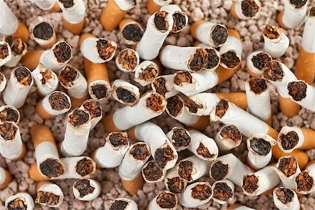 simsearch:400-06876304,k - Ashtray full of smoked cigarettes in the sand closeup from above Stock Photo - Budget Royalty-Free & Subscription, Code: 400-07794464