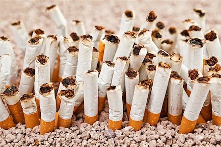 simsearch:400-06876304,k - Ashtray full of smoked cigarettes in the sand disposed as a wall Foto de stock - Super Valor sin royalties y Suscripción, Código: 400-07794474