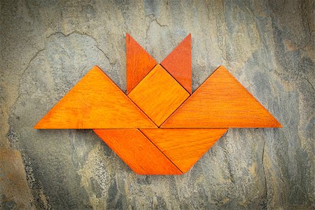 abstract picture of a flying bat built from seven tangram wooden pieces over a slate rock background, Halloween concept, artwork created by the photographer Stock Photo - Budget Royalty-Free & Subscription, Code: 400-07794795
