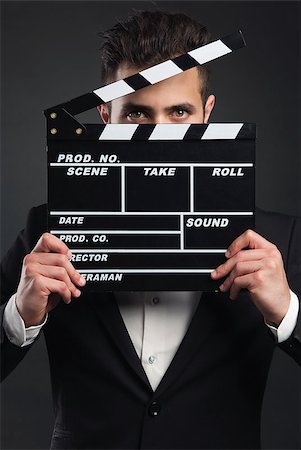 peeping fashion - Studio portrait of a young man with a suit and holding a clapboard Stock Photo - Budget Royalty-Free & Subscription, Code: 400-07794852