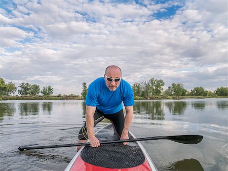 simsearch:400-07795226,k - senior male paddler boarding a stand up paddleboard (SUP), calm lake in Colorado, late summer Foto de stock - Royalty-Free Super Valor e Assinatura, Número: 400-07795120