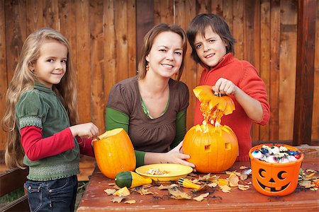 Kids carving jack-o-lanterns for Halloween - with a little help from their mother Stock Photo - Budget Royalty-Free & Subscription, Code: 400-07795532