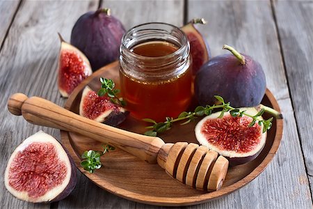 Ripe purple figs, thyme and homey on olive board. Selective focus. Stock Photo - Budget Royalty-Free & Subscription, Code: 400-07795836